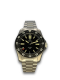 Round stainless steel watch with dark dial, gold tone accents, and metal bracelet